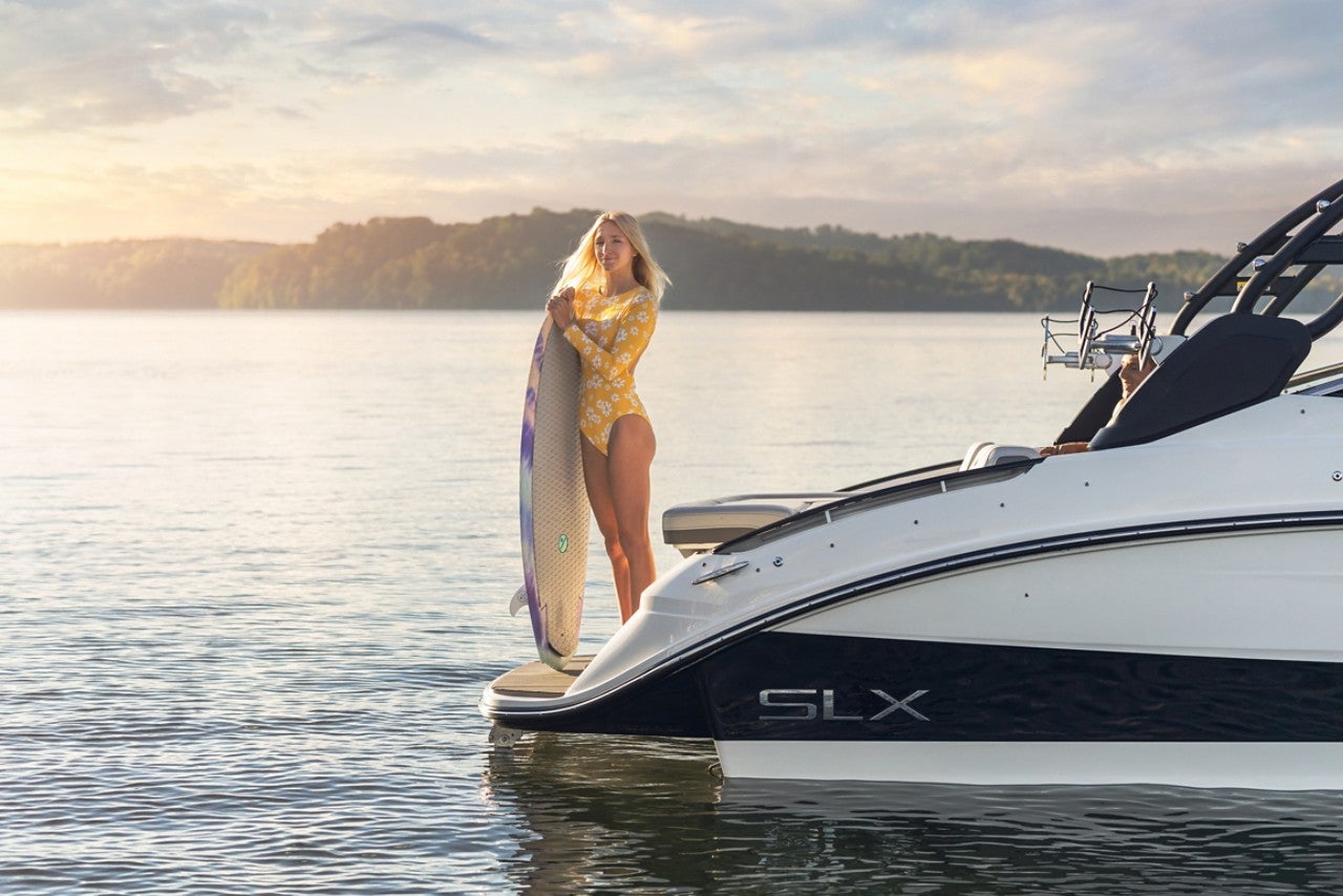 Woman with wakesurf board on an SLX 260 Surf