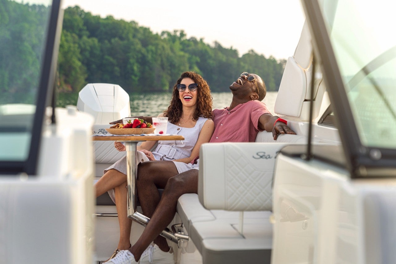 Couple sitting at the cockpit table in an SDX 270 Outboard