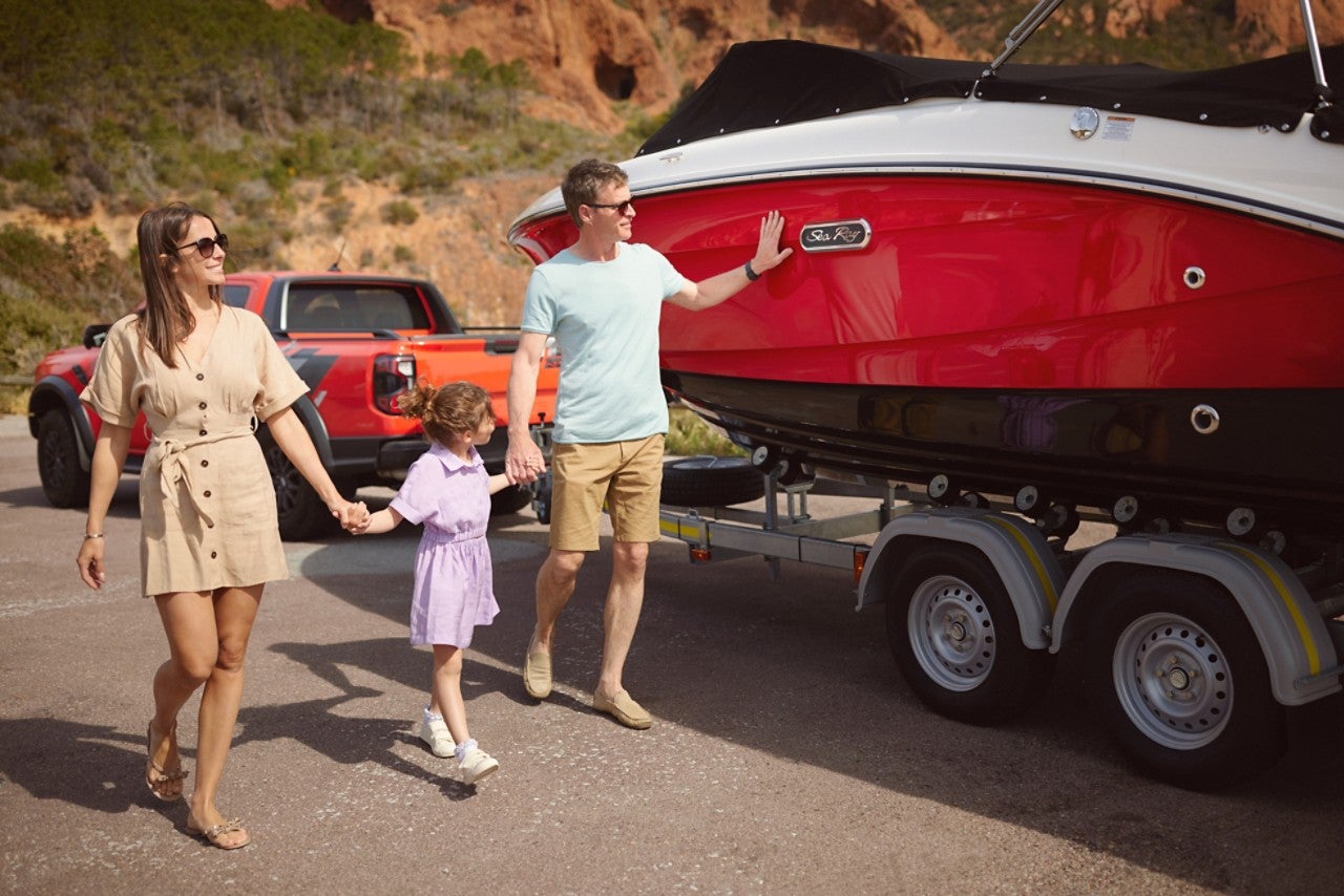 Family next to an SPX 210 Outboard on a trailer