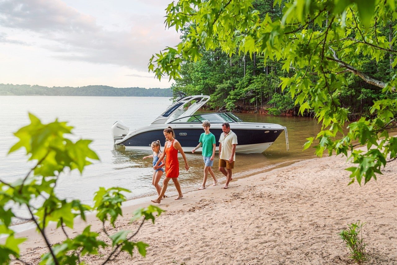 Family walking on a beach next to an SDX 250 Outboard