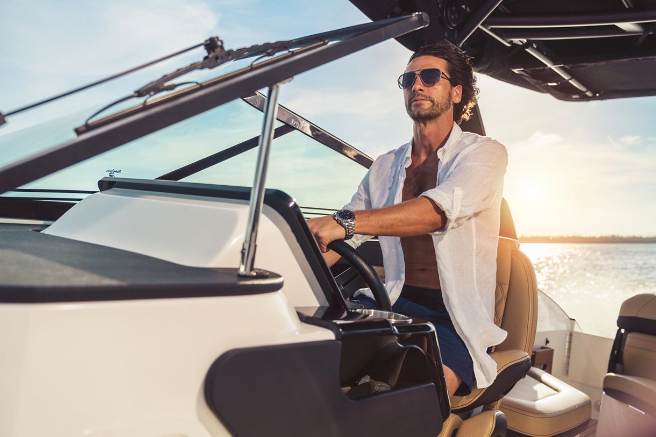 Man sitting at the helm of an SLX 260 Outboard