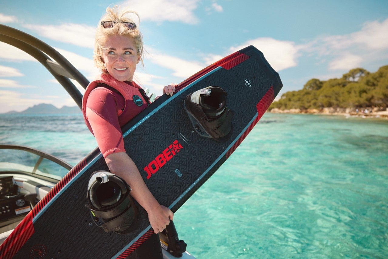 Woman holding a wakeboard aboard an SPX 210