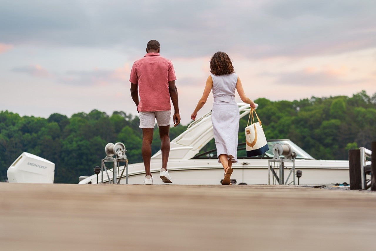 Couple walking towards an SDX 270 Outboard at a dock