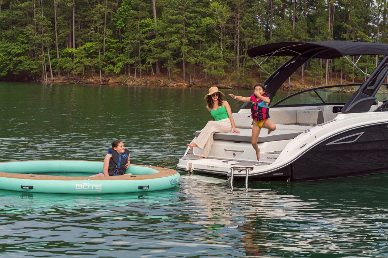 Girl jumping in the water from an SDX 250 while her mom and brother watches