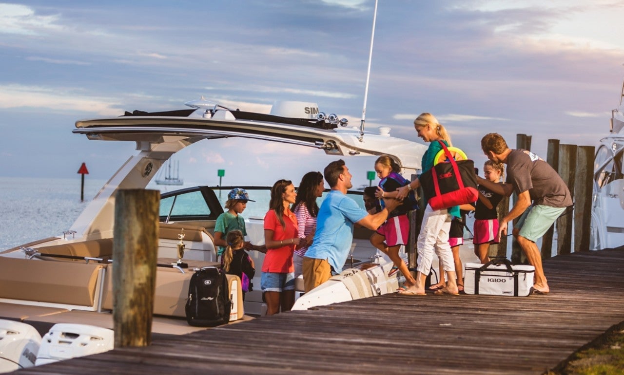 2024 SLX 400 Outboard starboard stern view of family friends at dock