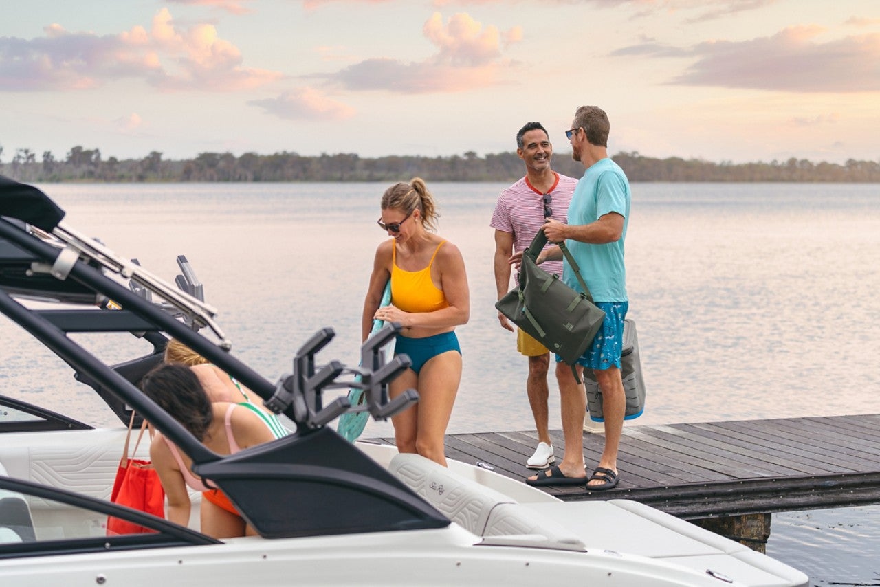 People boarding an SDX 270 Surf from a dock