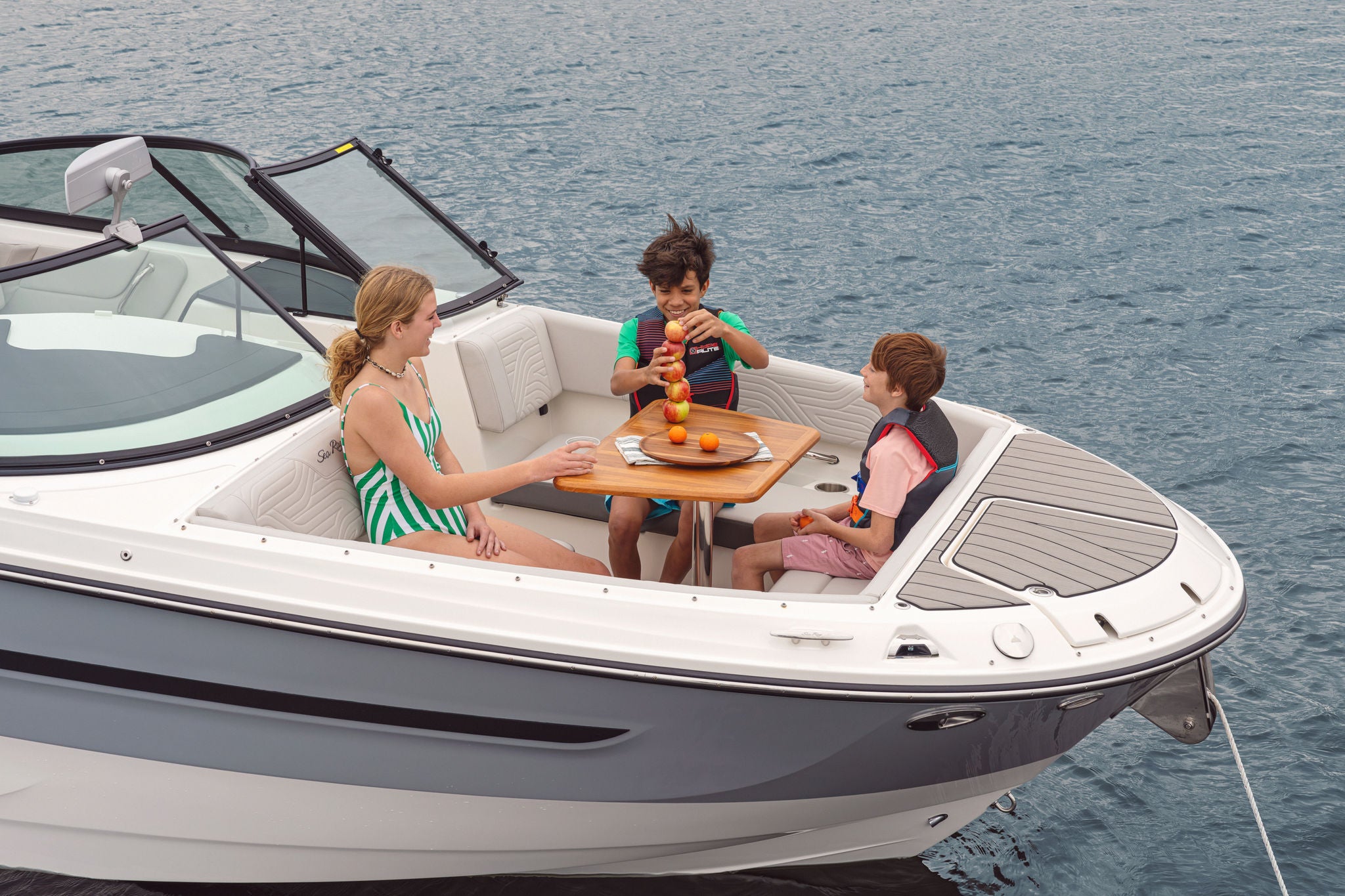 Kids eating a snack in the bow of an SDX 270 Surf